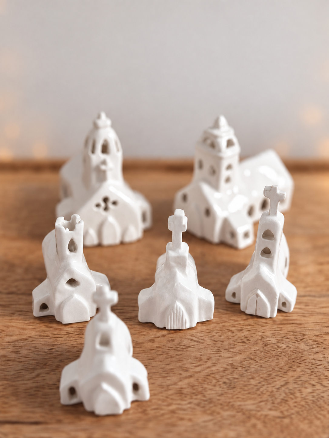 White ceramic church figurines arranged on wooden surface